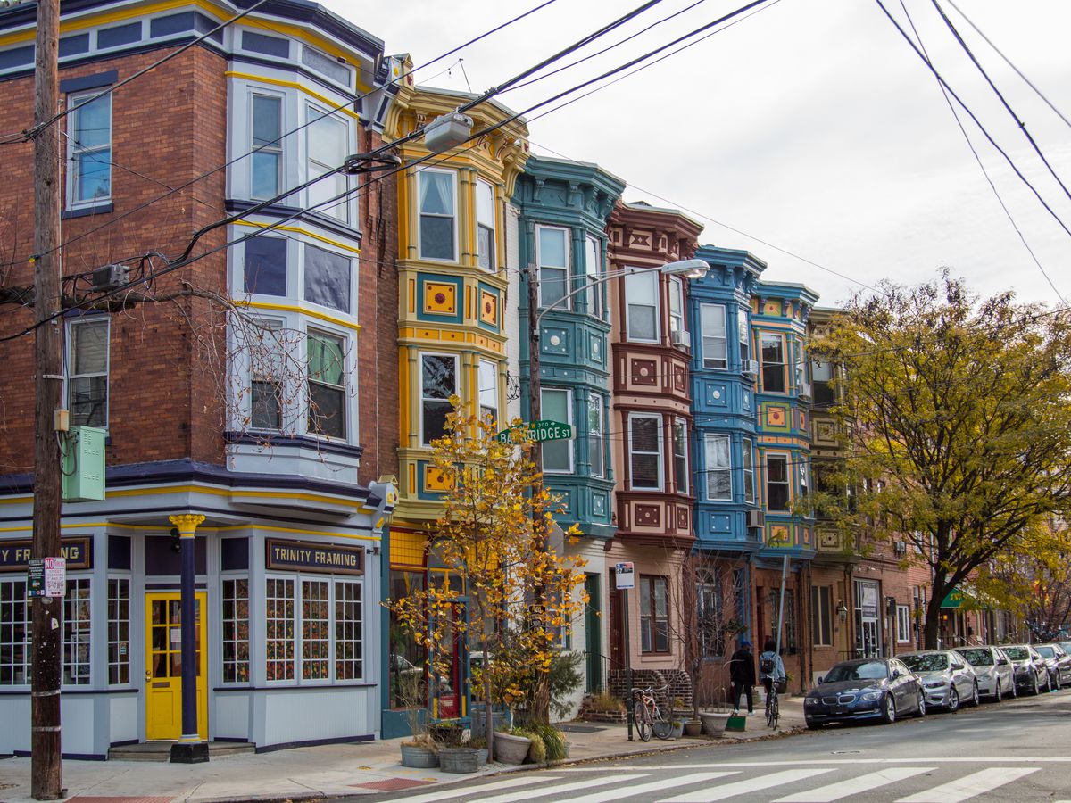 A row of colorful houses in Philadelphia known as Fabric Row. There are various fabric stores and shops on the ground floors of the buildings. 