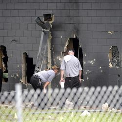 Police officials investigate the back of the Pulse nightclub after a shooting involving multiple fatalities at the nightclub in Orlando, Fla., Sunday, June 12, 2016. 