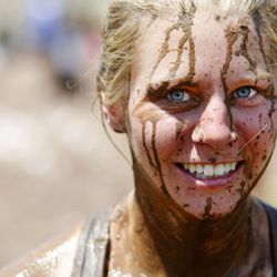 Felisha Hurst smiles as she exits a mud hole as she competes Saturday, June 29, 2013, in the Spartan Race at Soldier Hollow.