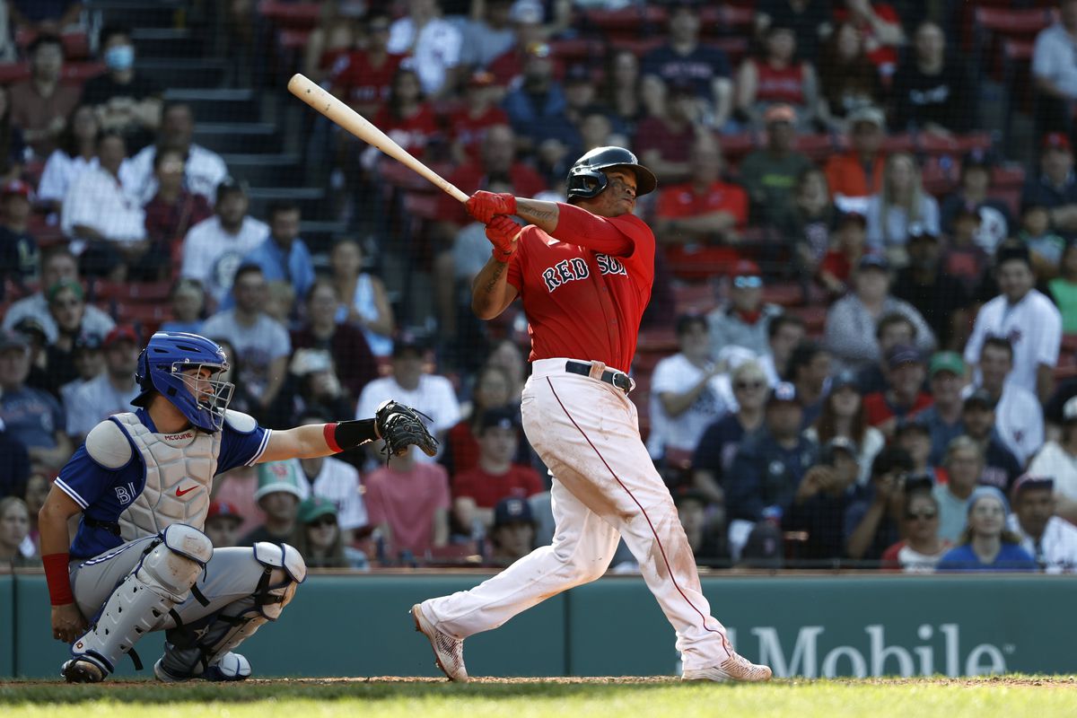 Rafael Devers #11 of the Boston Red Sox follows through on a hit against the Toronto Blue Jays during first game of a doubleheader at Fenway Park on July 28, 2021 in Boston, Massachusetts.
