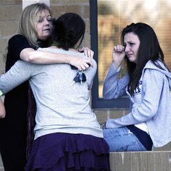 Lexie Shipman, age 13, at right, wipes a tear away as her mother, Tami, and sister Tristan console themselves as they pick Lexie up after the shooting at Deer Creek Middle School in Littleton, Colo. on Tuesday.