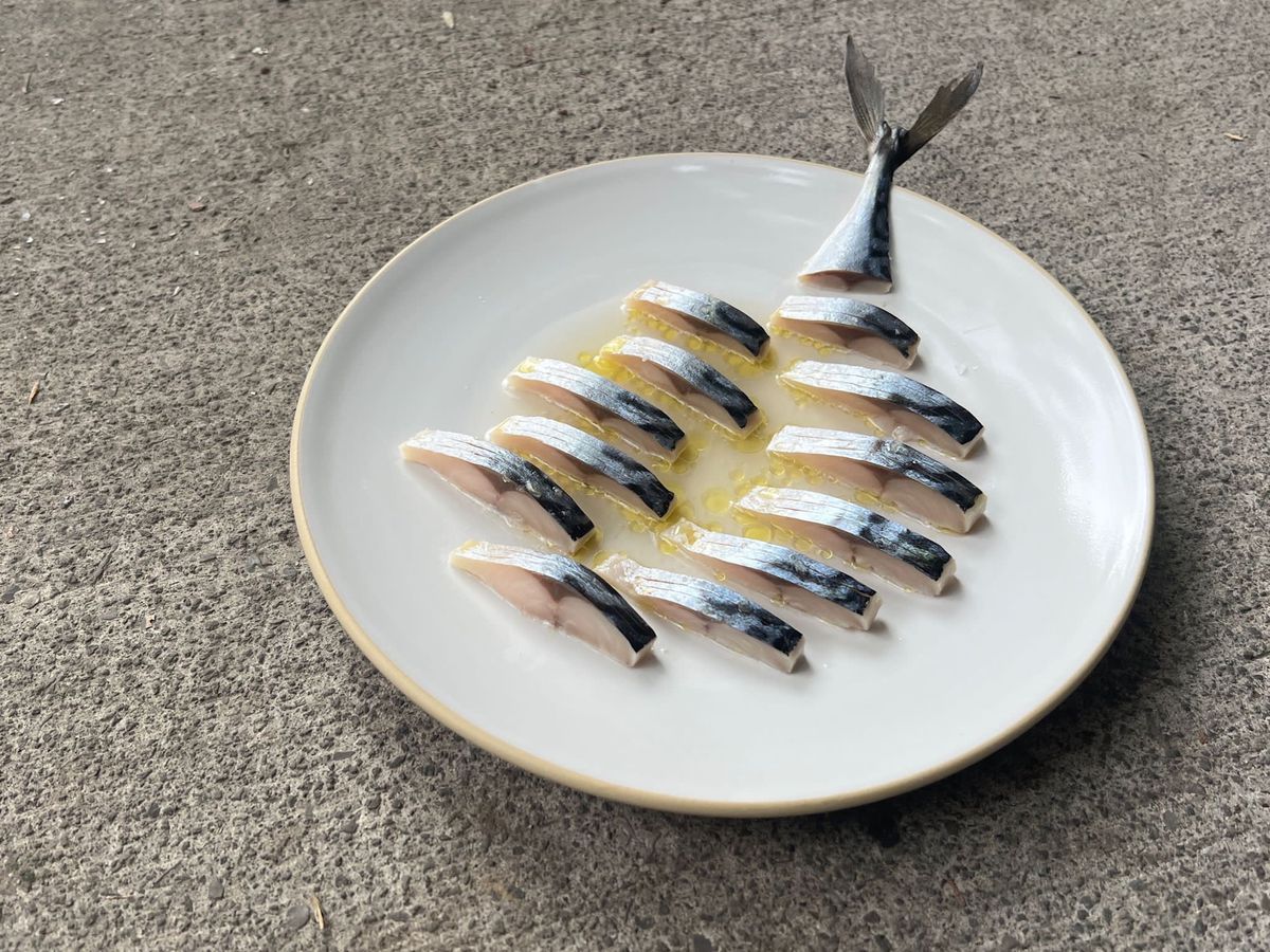 A piece of fish sliced into small portions and arranged geometrically.