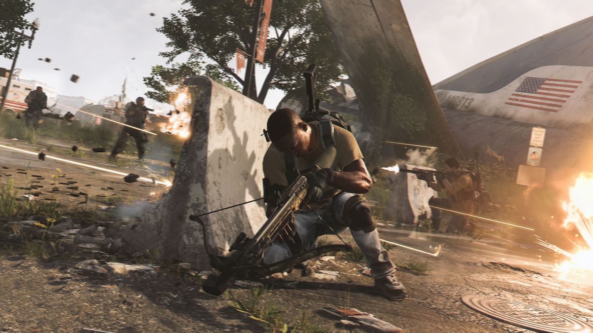 a soldier crouching behind a barrier to avoid gunfire in The Division 2
