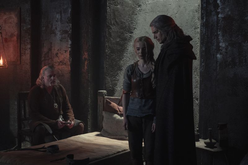 Ciri standing with Geralt and Vessemir in a still from season 2 of The Witcher