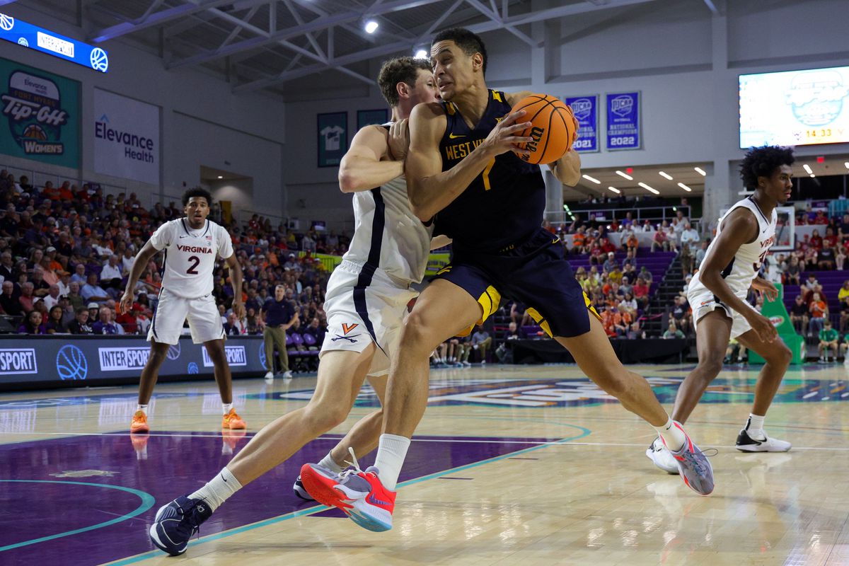 West Virginia Mountaineers center Jesse Edwards drives tot eh hoop past Virginia Cavaliers forward Jacob Groves in the second half during the Fort Myers Tip-Off third place game at Suncoast Credit Union Arena.&nbsp;