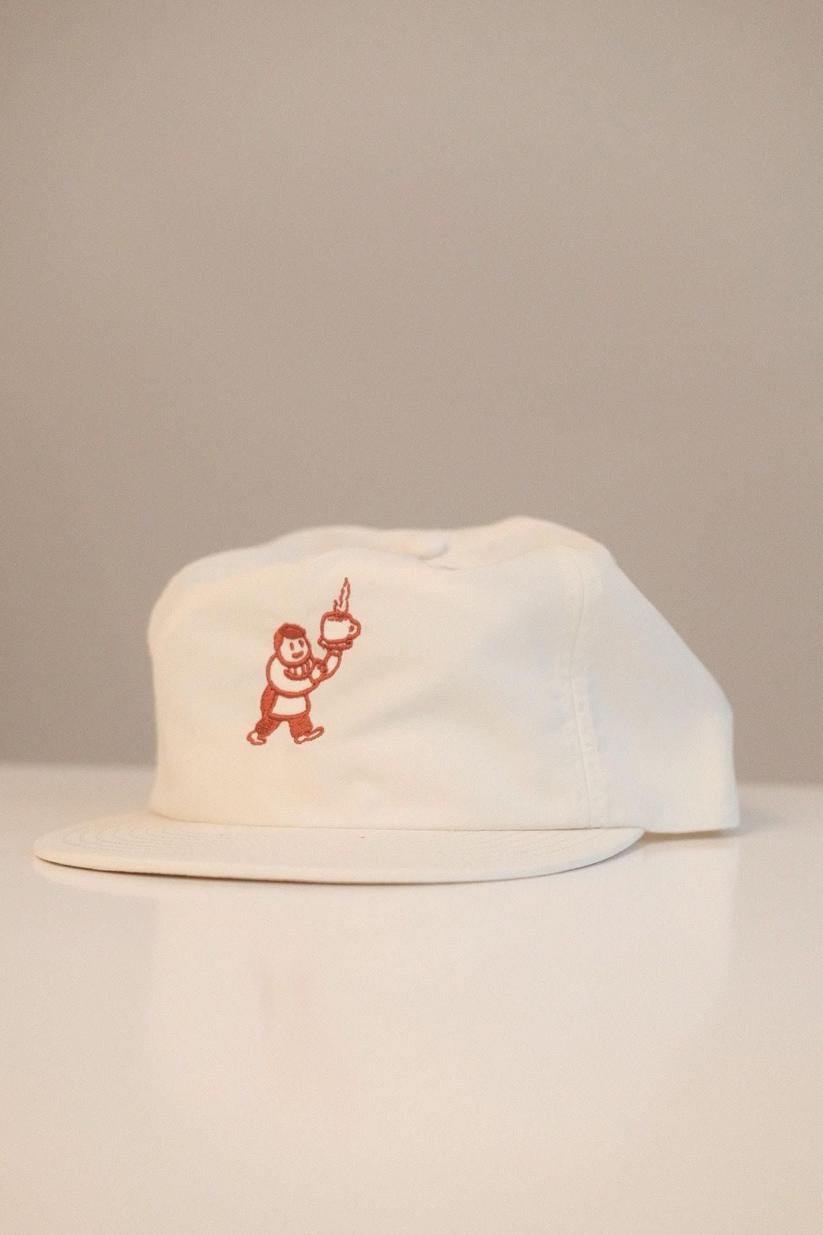 A white hat with a red illustration.