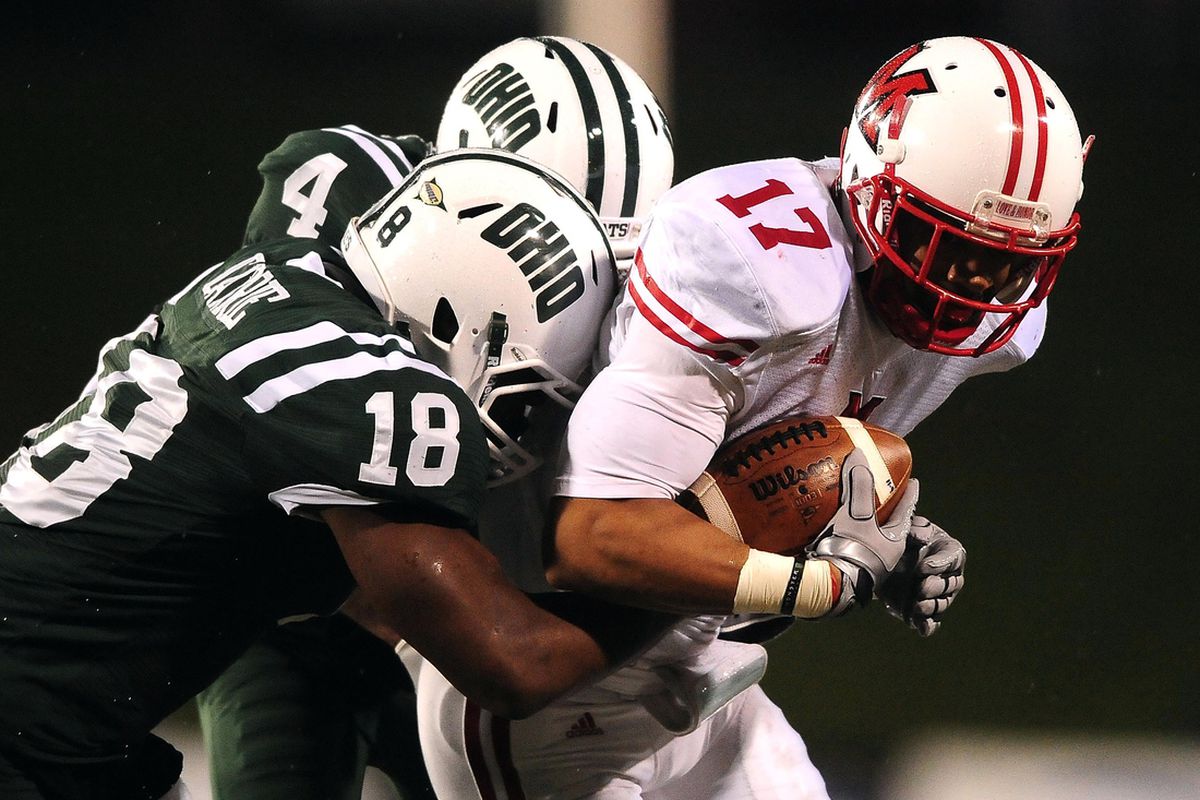 Nov 22, 2011; Athens, OH, USA; Miami Redhawks wide receiver Chris Givens (17) is tackled by Ohio Bobcats cornerback Travis Carrie (18) and cornerback Omar Leftwich (4) at Peden Stadium. (Andrew Weber-US PRESSWIRE)