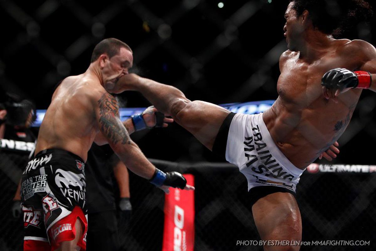 UFC lightweight champion Benson Henderson (right) kicks former champion Frankie Edgar (left) in the face during the fifth round of their lightweight title bout last night at UFC 150. Photo by Esther Lin via MMA Fighting