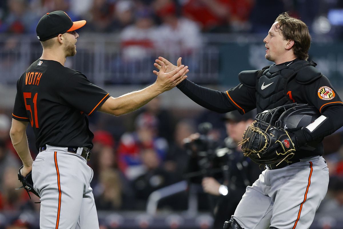 Austin Voth reacts with Adley Rutschman of the Baltimore Orioles at the conclusion of the 9-4 victory over the Atlanta Braves at Truist Park on May 5, 2023 in Atlanta, Georgia.