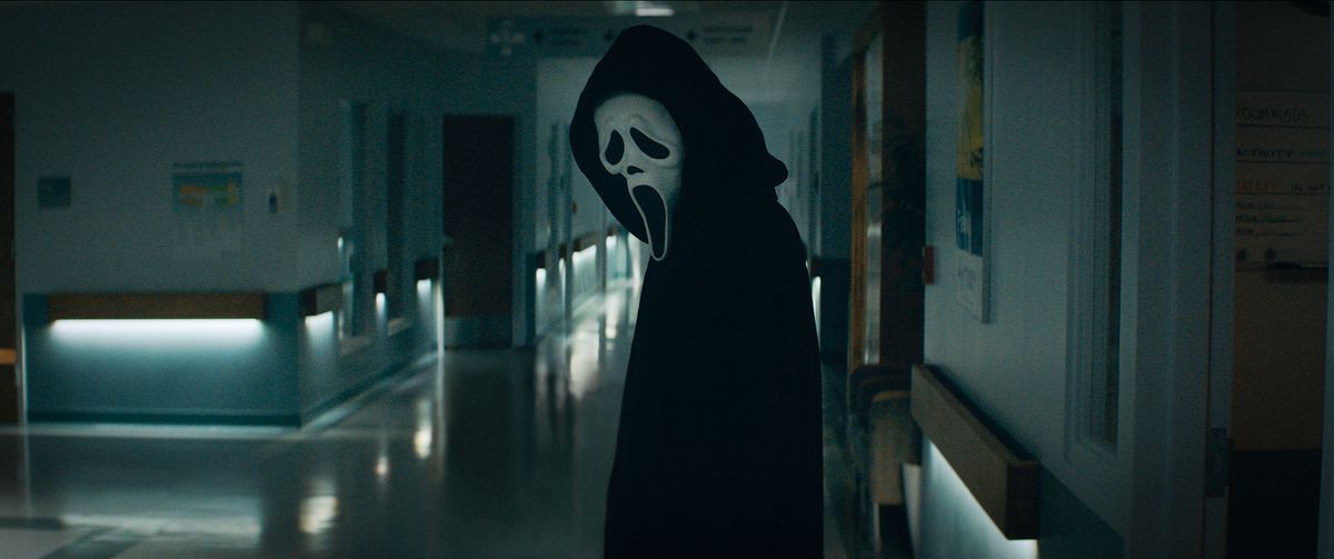 Ghostface looking down a hallway in Scream 2022