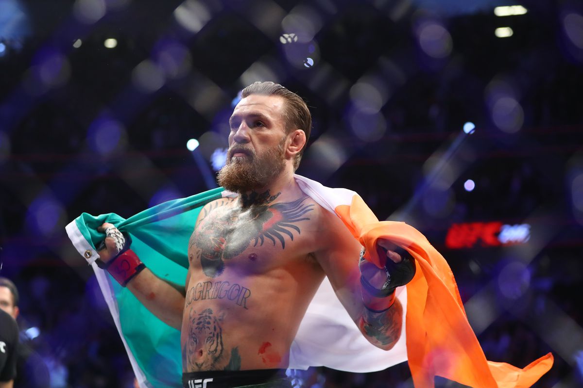 Conor McGregor holds an Irish flag as he celebrates his first round TKO victory against Donald Cerrone following UFC 246 at T-Mobile Arena.