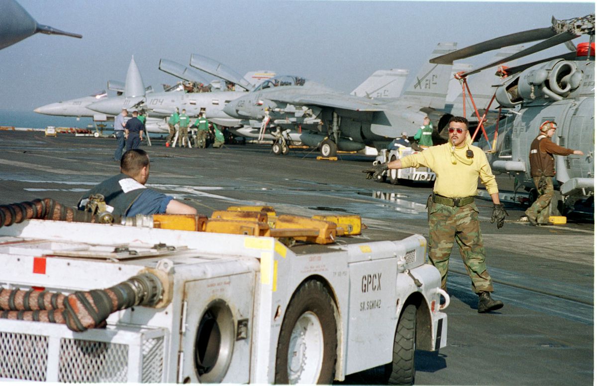 Crew members on the flight deck of the USS Enterprise perform maintenance...