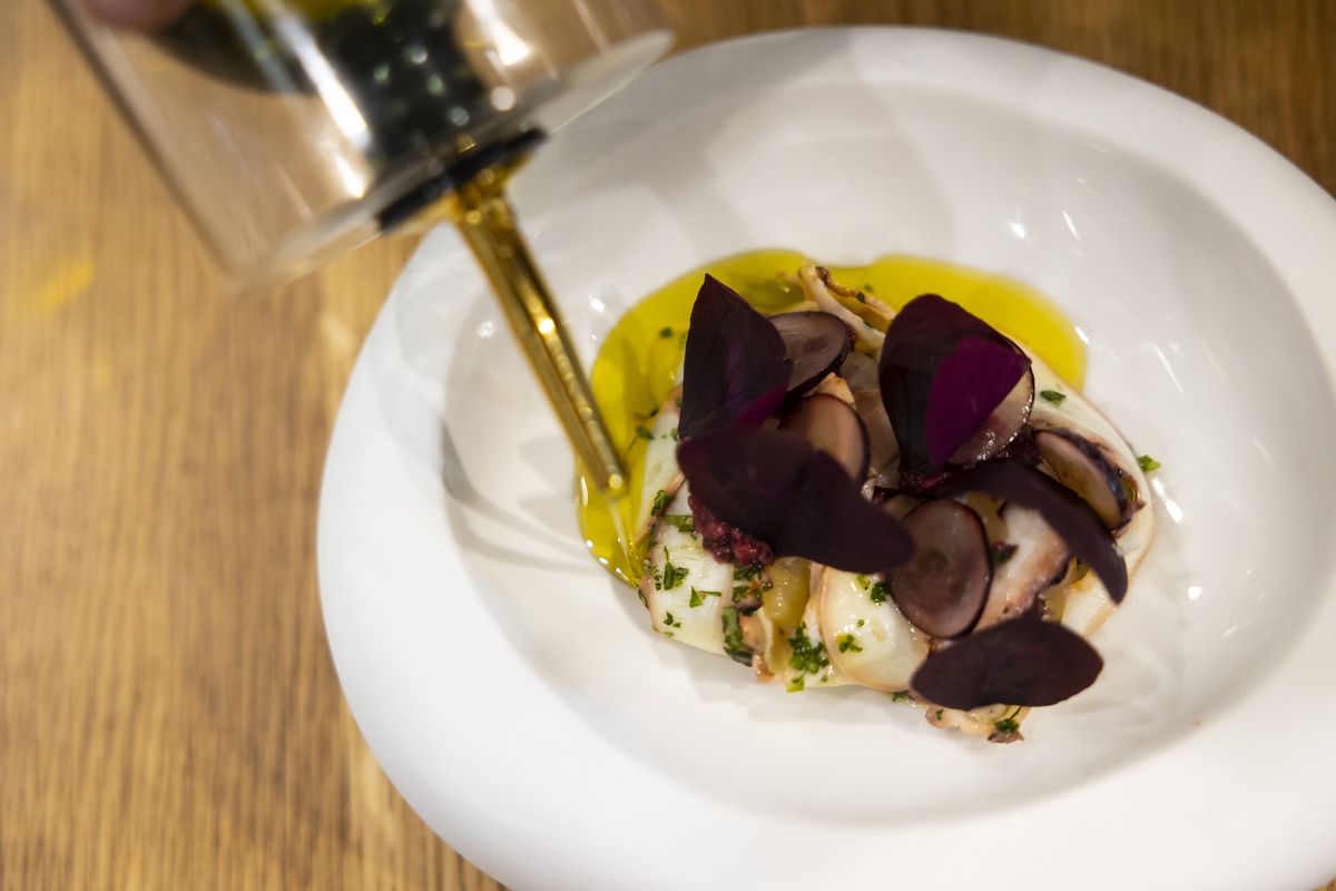 Fresh olive oil is added to the octopus dish.