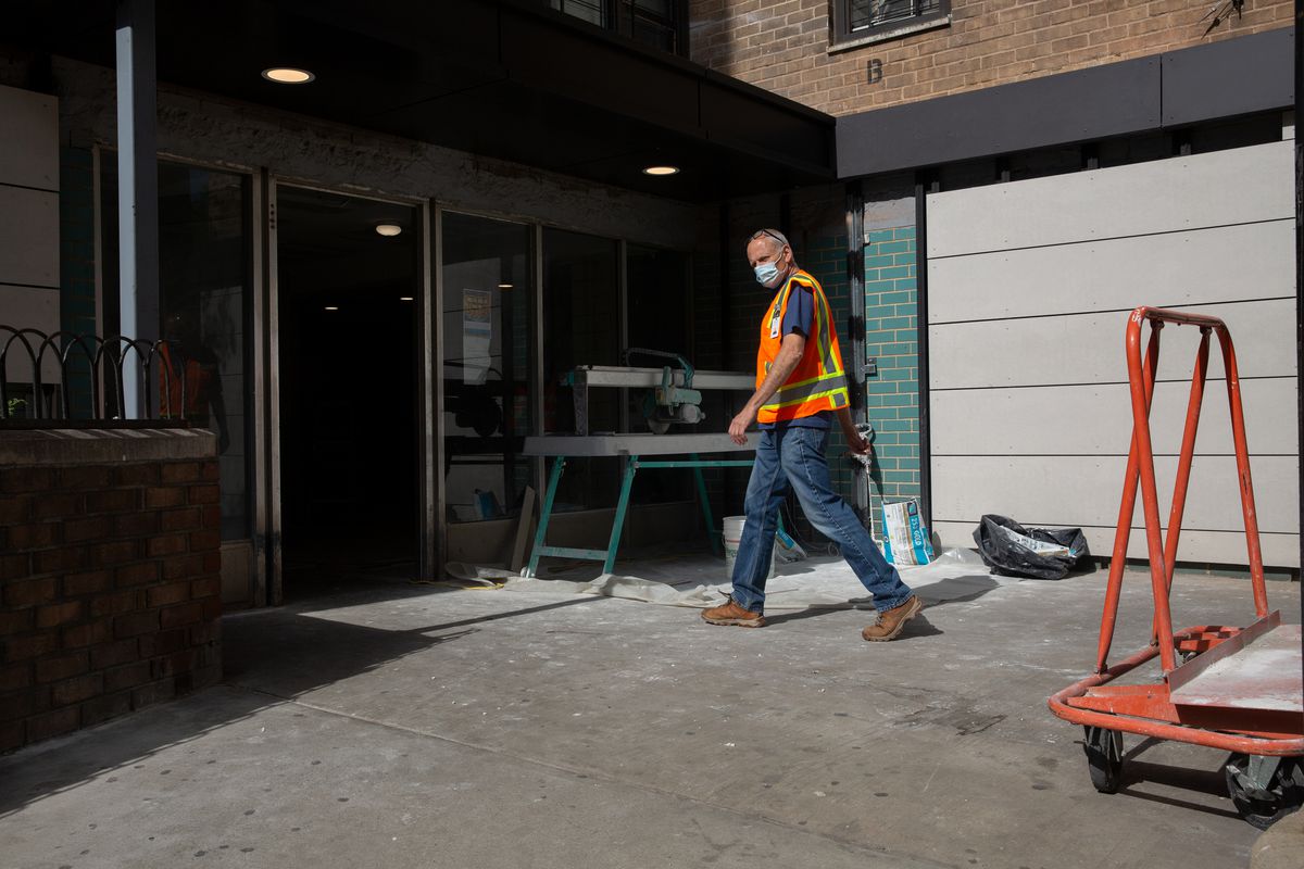 A worker for Renewal enters a NYCHA building on Wilson Street.