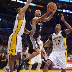 San Antonio Spurs guard Tony Parker, center, of France, shoots as Los Angeles Lakers forward Metta World Peace, left, and center Dwight Howard defend during the first half of their NBA basketball game, Sunday, April 14, 2013, in Los Angeles. 