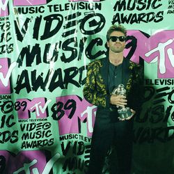 FILE - In this Wednesday, Sept. 6, 1989 file photo, musician George Michael holds his trophy after winning the 1989 Video "Vanguard Award" for his "Father Figure" video during the MTV Music Awards at the Universal Ampitheatre in Universal City, Calf. Michael, who rocketed to stardom with WHAM! and went on to enjoy a long and celebrated solo career lined with controversies, has died, his publicist said Sunday, Dec. 25, 2016. He was 53. 