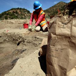 A paper bag filled with ceramic pieces unearthed by Montgomery Archaeological Consultants sits at the edge of a dig site in Nine Mile Canyon, May 17, 2012. The Fremont Indian pit house where the pieces were discovered is one of at least a dozen cultural sites that have been found in the past year by construction crews and archaeologists working on the Nine Mile Canyon Road. 