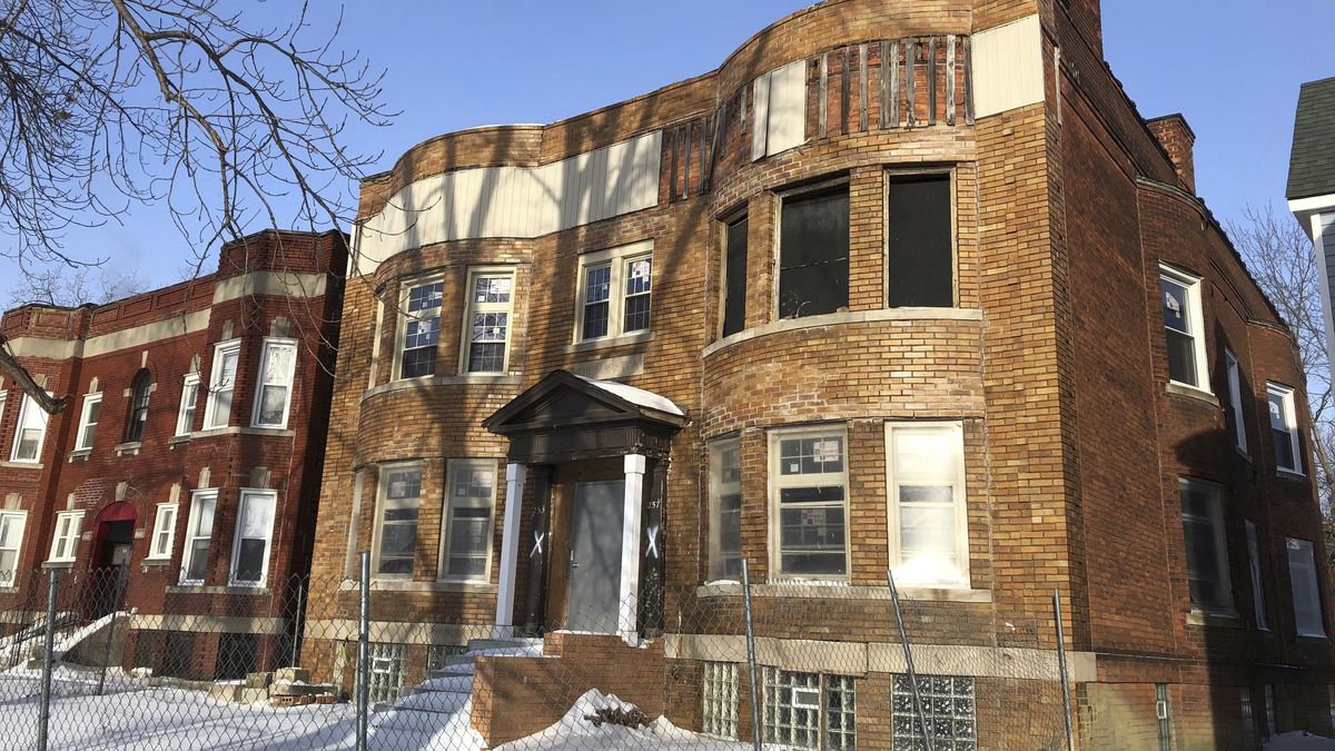A symmetrical two-story brick building. There’s snow on the ground.