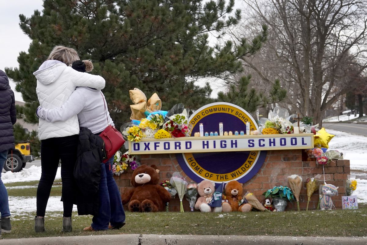 People embrace as they visit a makeshift memorial outside of Oxford High School on December 01, 2021, in Oxford, Michigan. 