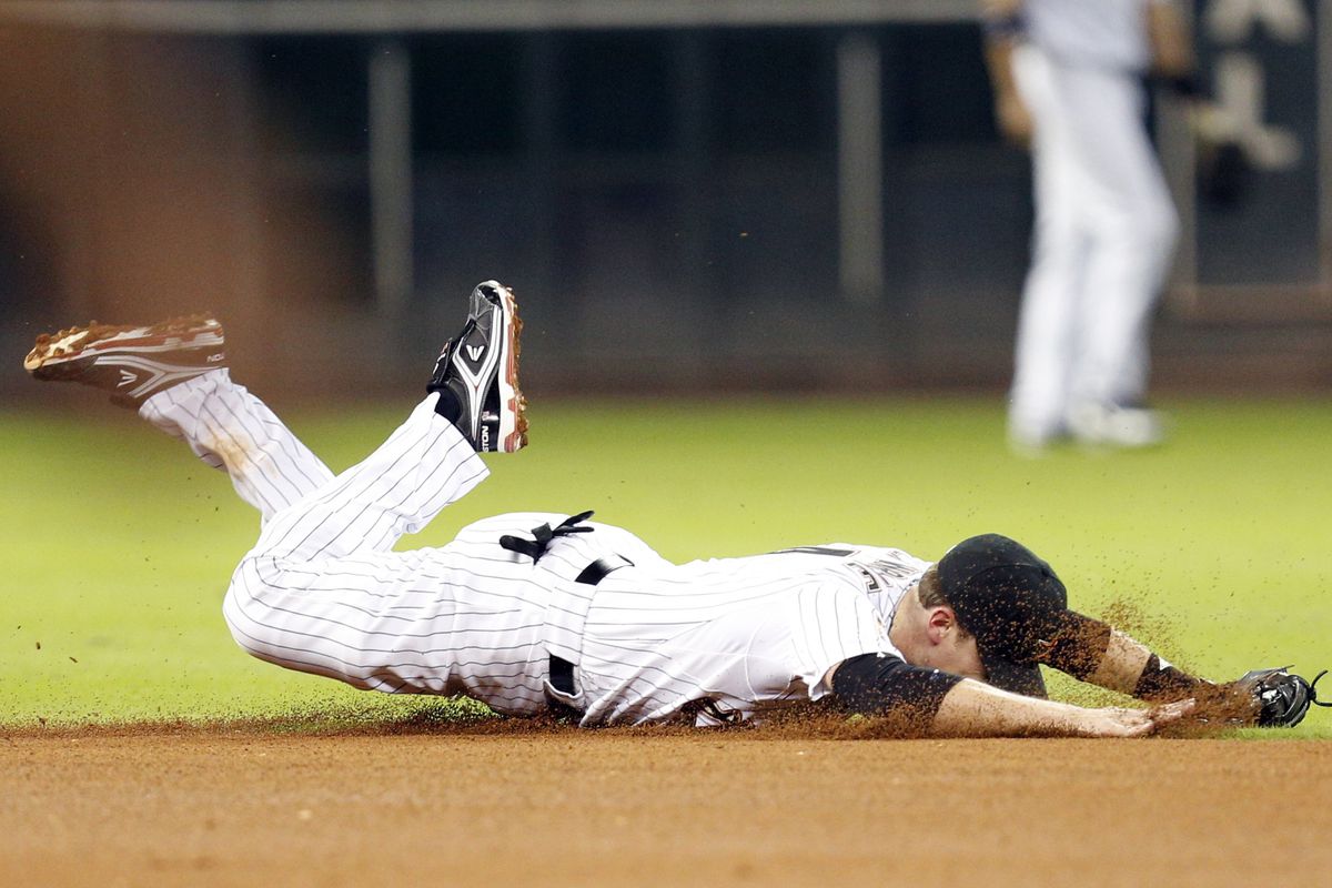 Sept 12, 2012; Houston, TX, USA; Houston Astros shortstop Jed Lowrie (4) dives for a ground ball against the Chicago Cubs during the fourth inning at Minute Maid Park. Mandatory Credit: Thomas Campbell-US PRESSWIRE