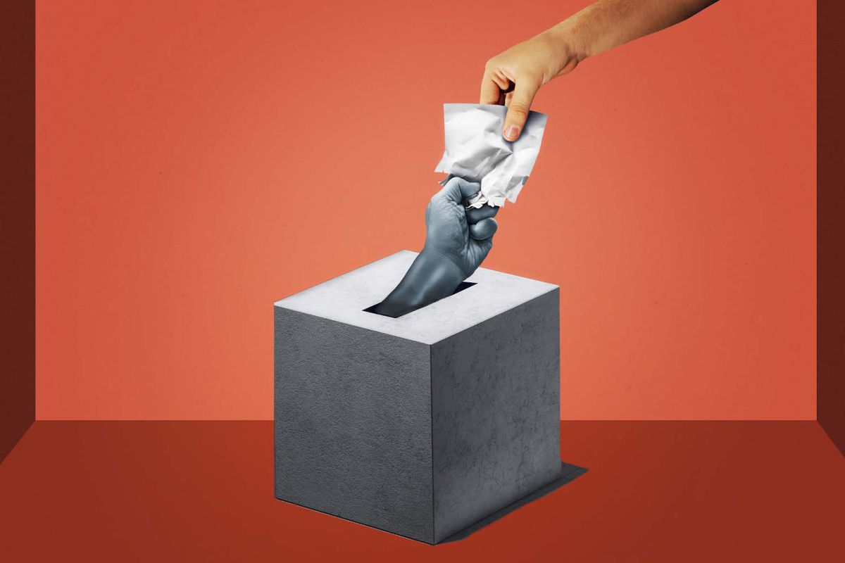 A photo illustration against a red background shows one hand, in color, trying to put a piece of paper into a grayscale ballot box with another hand, in gray, reaching up from the box to pull the paper down.