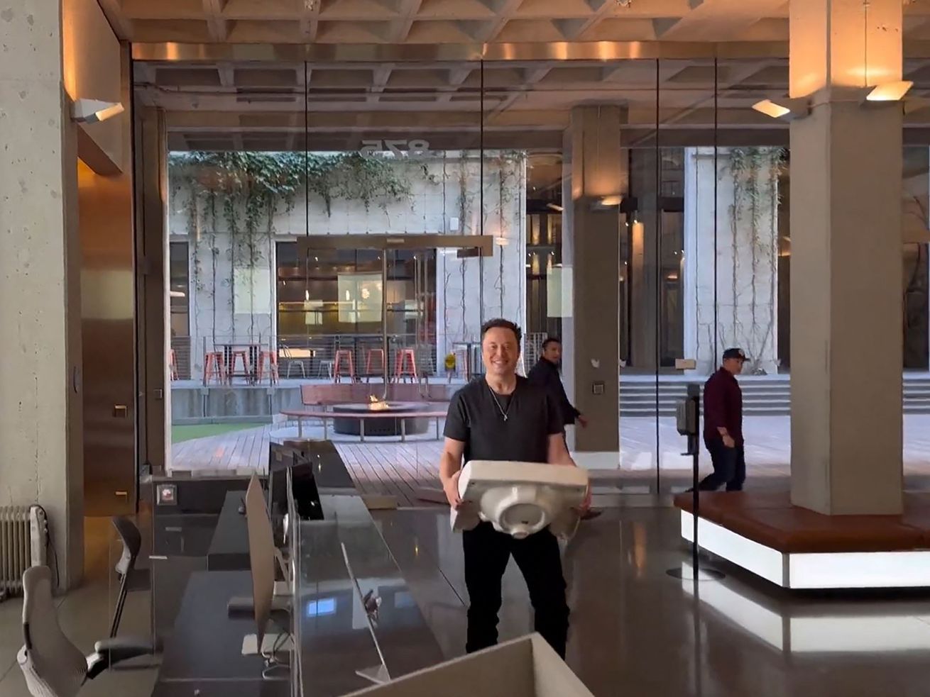 Elon Musk walking into Twitter headquarters carrying a bathroom sink.