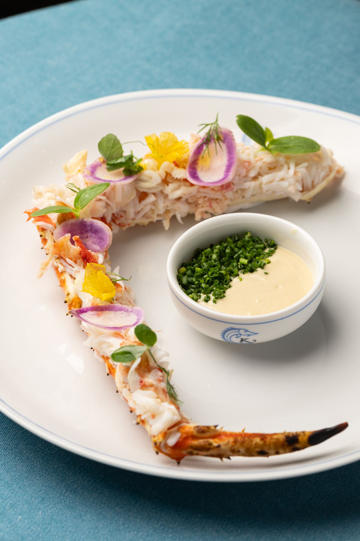 A king crab leg with edible flowers and a side of dijon aioli at Caviar Kaspia.