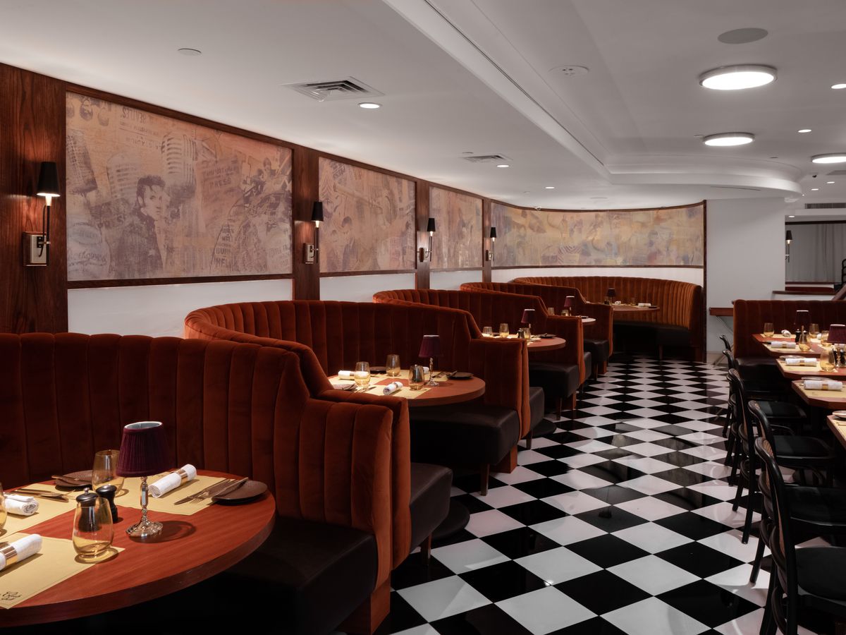 A checkered floor with velvet banquettes of Press Club Grill. 