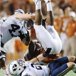 BYU's Dallin Leavitt takes out Malcolm Browns legs and teammate Zac Stout finishes him off as BYU and Texas play Saturday, Sept. 6, 2014, in Austin Texas. BYU won 41-7.