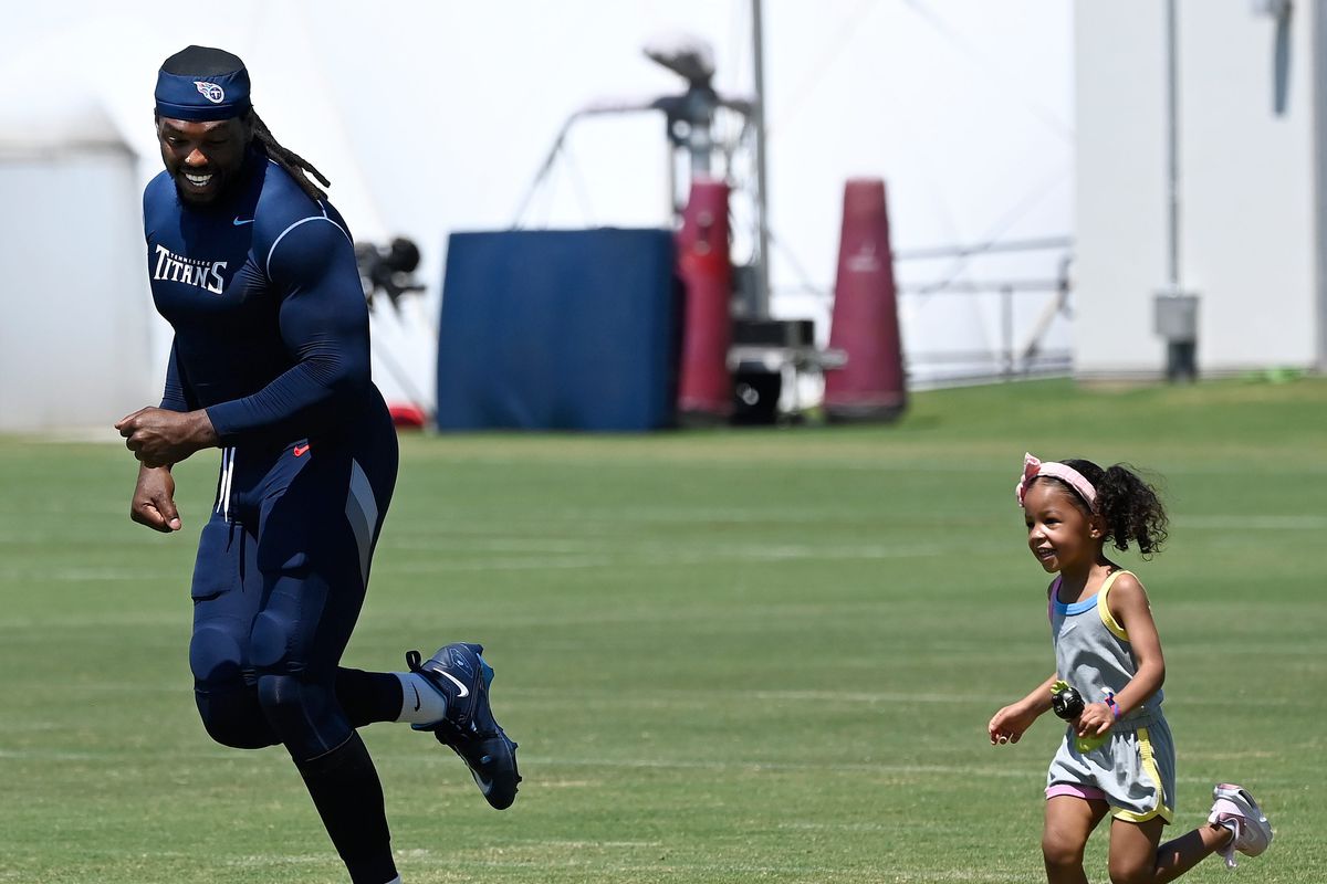 Tennessee Titans running back Derrick Henry (22) runs with his daughter Valentina on the field after an NFL football training camp practice Monday, July 31, 2023, in Nashville, Tenn.