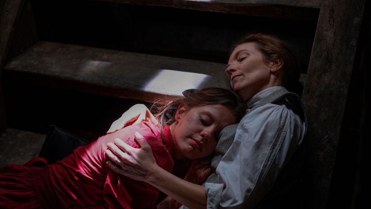 Pearl (Mia Goth) lies on a basement staircase in the arms of her mother Ruth (Tandi Wright) in Ti West’s Pearl