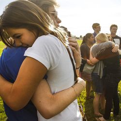 Abigail Lopez, right, and Chase Kingsford, friends and co-workers of both Maddison Haan, 20, and Tyler Christianson, 19, embrace each other during a vigil in Roy on Friday, July 1, 2016. The vigil was for Christianson and Haan, who died while driving after being hit by Marilee Patricia Gardner, 16, who was going 100 mph and who police say attempting to commit suicide.