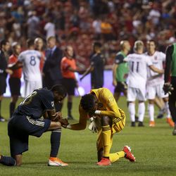 A pair of Philadelphia Union players say a prayer while Real Salt Lake celebrates in the background at the end of the game at Rio Tinto Stadium in Sandy on Saturday, July 13, 2019. Real Salt Lake defeated Philadelphia Union 4-0.