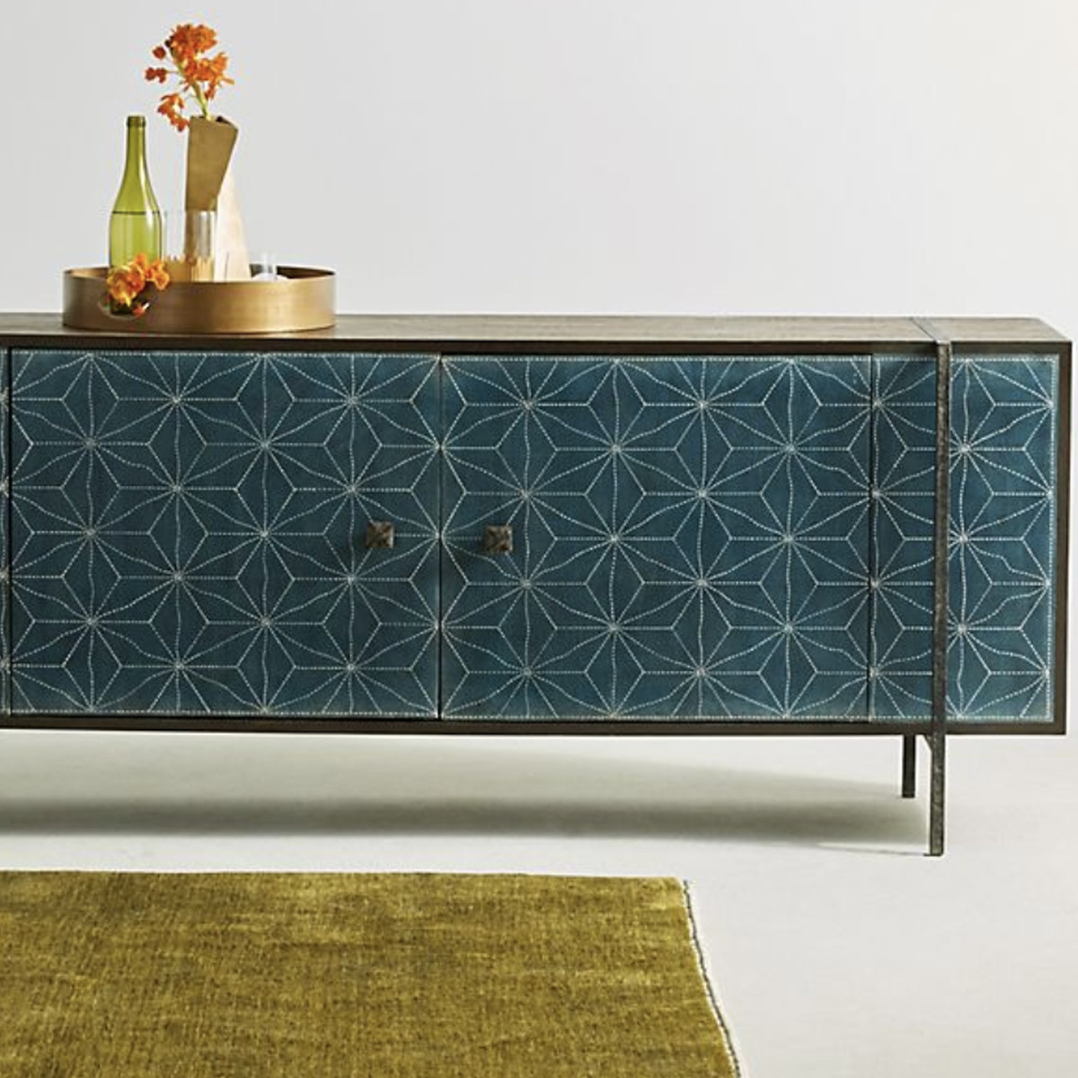 A credenza with blue doors, a metal frame, and a star pattern painted on it