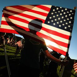 Cody Brophy volunteers with others to set up 3,000 flags in the Utah Healing Field in Sandy on Thursday, Sept. 8, 2016, to honor the victims of the 9/11 terrorist attacks.