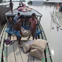Indian flood affected villagers unload relief material from a boat in Morigaon district, east of Gauhati, northeastern state of Assam, Tuesday, Aug. 15, 2017. Heavy monsoon rains have unleashed landslides and floods that killed dozens of people in recent days and displaced millions more across northern India, southern Nepal and Bangladesh. (AP Photo/Anupam Nath)