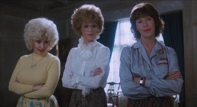Dolly Parton, Jane Fonda, and Lily Tomlin cross their arms in 9 to 5.