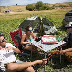 Ben Stahl, Darla Green, both of Berkeley, Calif., and Ben Ryan, of Oakland, Calif., play board games and bide time until Monday morning's total solar eclipse at Mann Creek Reservoir, north of Weiser, Idaho, on Sunday, Aug. 20, 2017.
