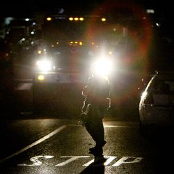 A tactically geared officer guides a vehicle out of the command post on Connor Street after the fatal shooting near the University of Utah in Salt Lake on Monday, Oct. 30, 2017.