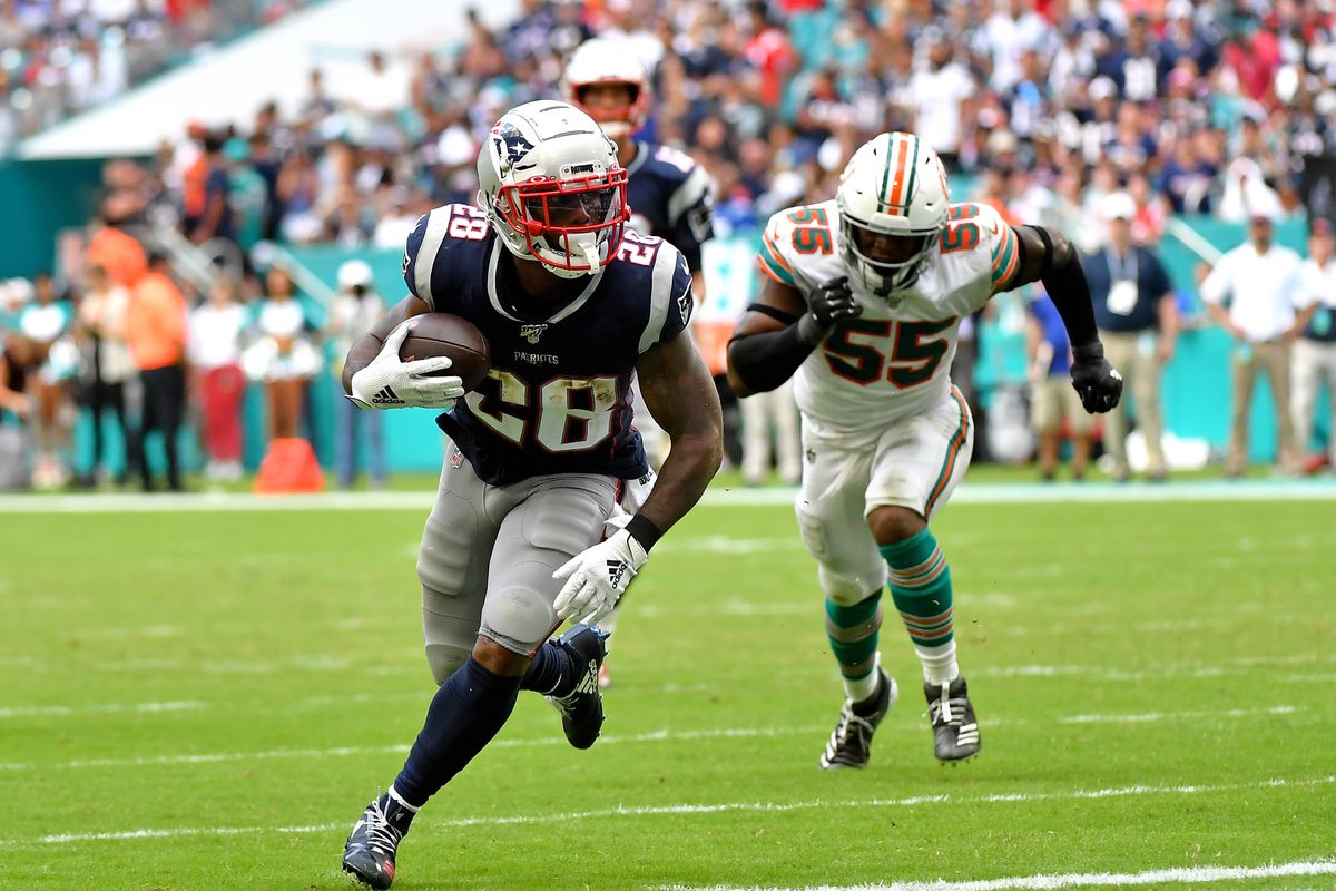 New England Patriots running back James White carries the ball for a touchdown past Miami Dolphins outside linebacker Jerome Baker during the second half at Hard Rock Stadium.