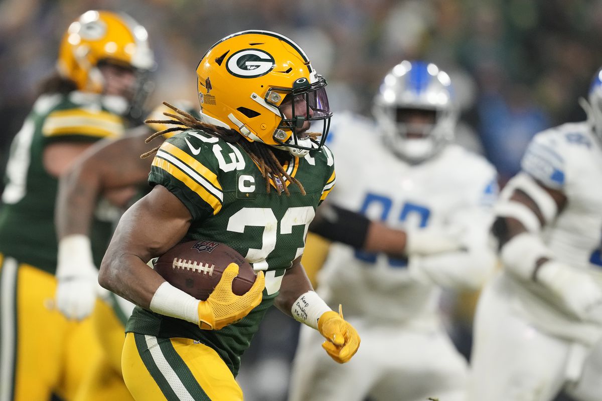 Aaron Jones #33 of the Green Bay Packers runs with the ball against the Detroit Lions in the second half at Lambeau Field on January 08, 2023 in Green Bay, Wisconsin.