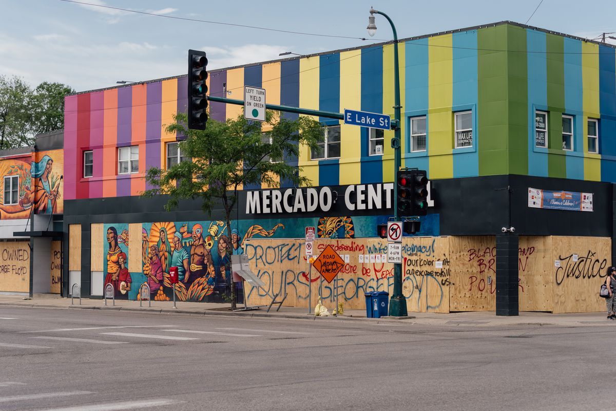 The exterior of Mercado Central, windows covered in plywood, but decorated with calls for justice for George Floyd