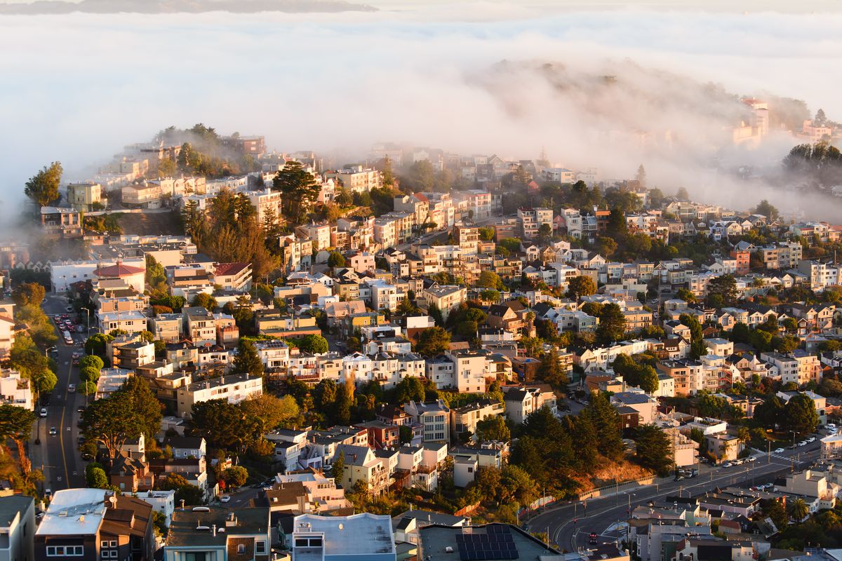 homes in SF shrouded in fog on a hill.