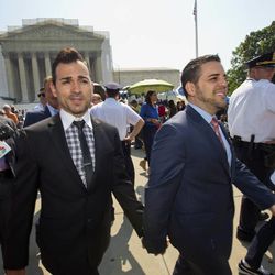 Proposition 8 case plaintiffs, Jeff Zarrillo, center, holds hands with his partner Paul Katami, right, as they leave the Supreme Court in Washington, Tuesday, June 25, 2013, without a decision in Hollingsworth v. Perry, California Proposition 8 case. At far left is plaintiff Kris Perry.   (AP Photo/J. Scott Applewhite)