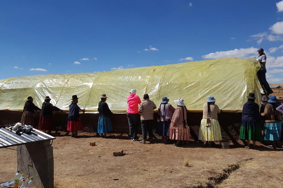 Community members and volunteers from Salt Lake City marketing firm Experticity construct a greenhouse in a rural village in Bolivia as part of a service expedition last August. The company recently instituted a new benefit policy that pays its employees 