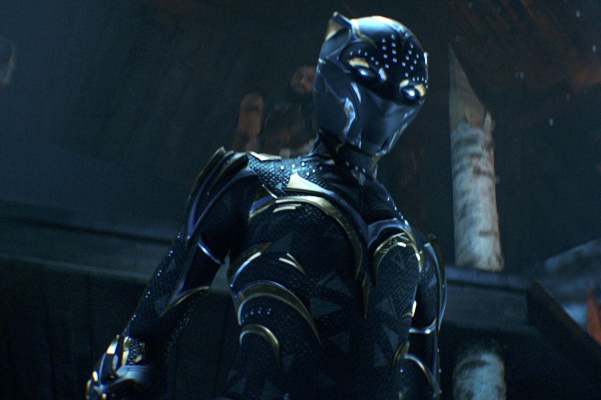 A female Black Panther stands up in a suit with a bejeweled mask