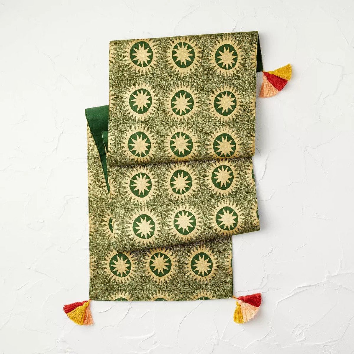 A green table runner with tassels