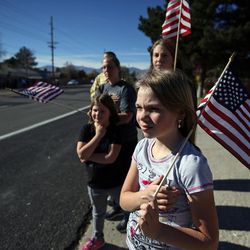 Kelsey Kerr and her family watch the procession of police vehicles move along 4100 South en route to the interment of West Valley police officer Cody Brotherson at Valley View Memorial Park in West Valley City on Monday, Nov. 14, 2016.