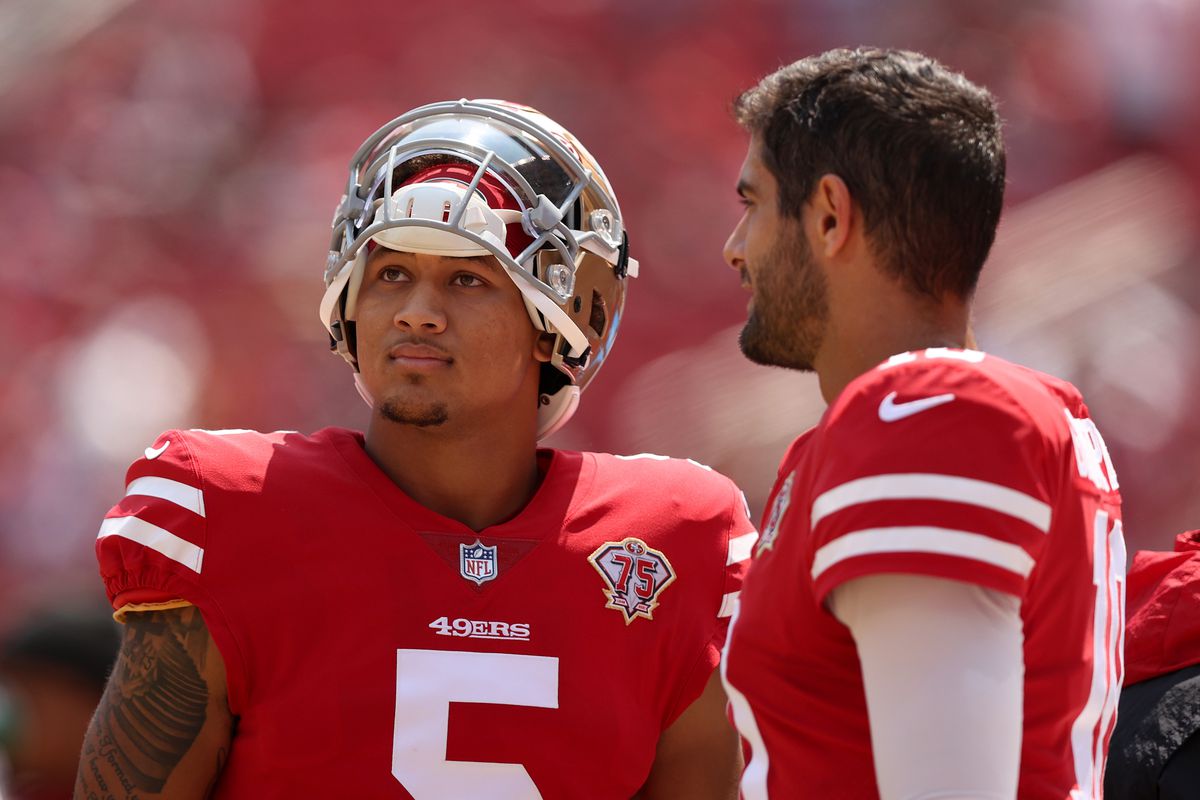 Jimmy Garoppolo #10 and Trey Lance #5 of the San Francisco 49ers talk to each other on the sidelines before their preseason game against the Las Vegas Raiders at Levi’s Stadium on August 29, 2021 in Santa Clara, California.