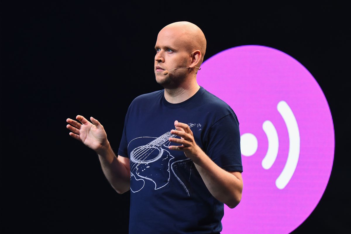Spotify CEO Daniel Ek standing onstage in front of a purple Spotify logo